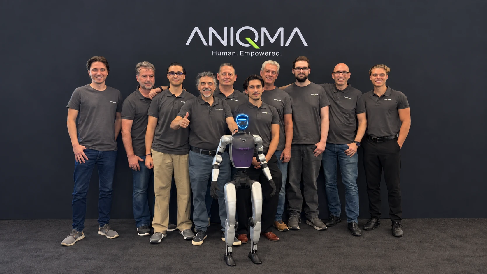 ANIQMA Team mit humanoidem Roboter vor dunklem Hintergrund und ANIQMA Logo